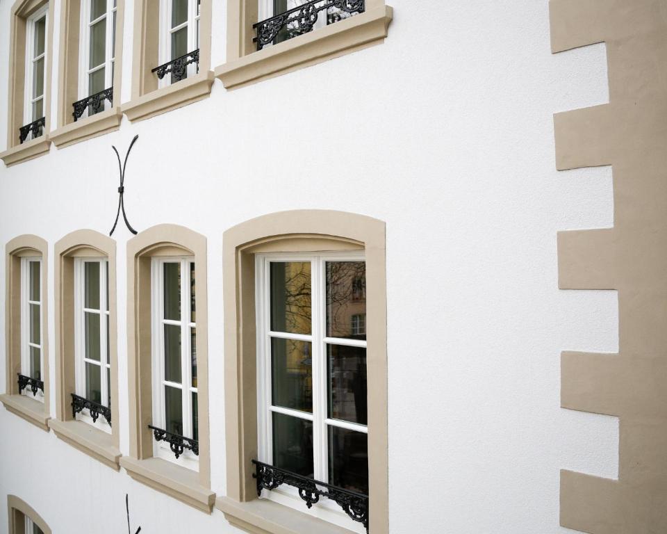 a row of windows on a white building at La Pipistrelle Hotel in Luxembourg