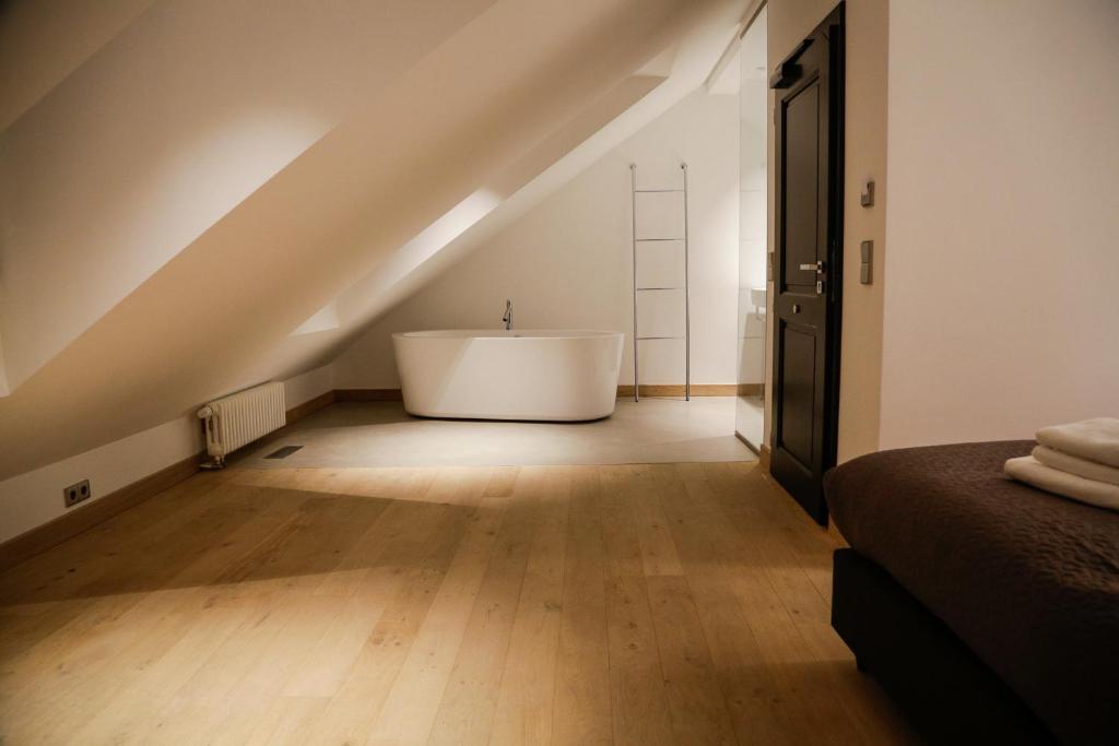 a bathroom with a bath tub in the middle of a attic at La Pipistrelle Hotel in Luxembourg