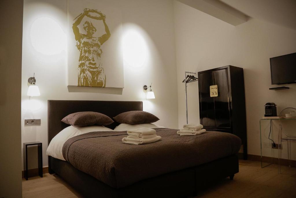 a bedroom with a bed with two towels on it at La Pipistrelle Hotel in Luxembourg
