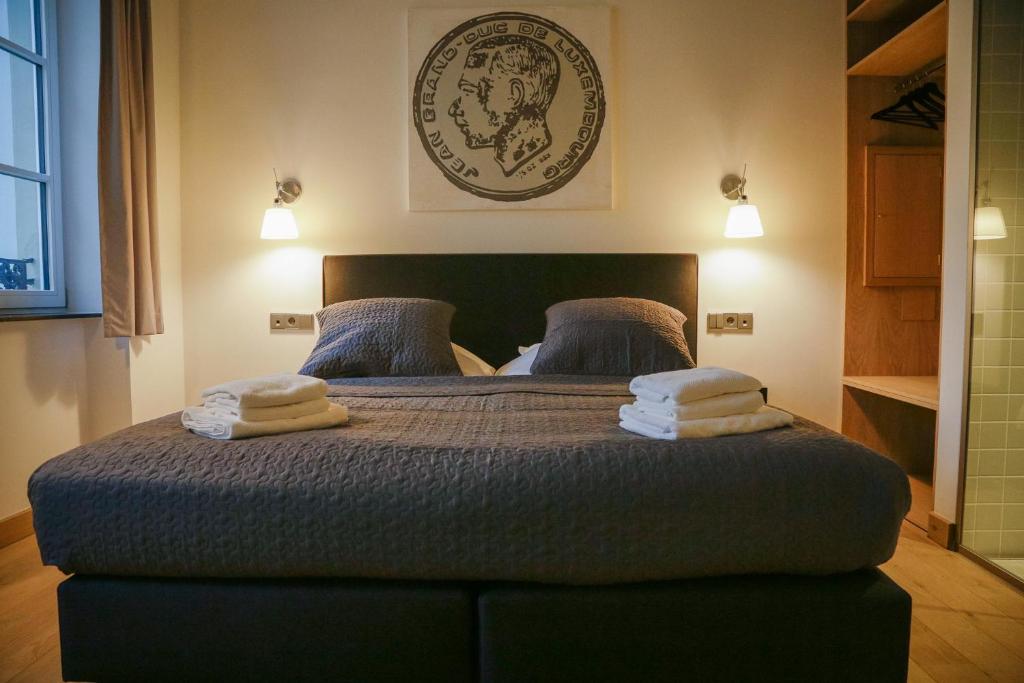 a bedroom with a bed with towels on it at La Pipistrelle Hotel in Luxembourg