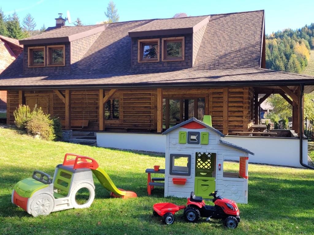 a house with toys in the grass in front of a house at Chata Claudia in Zázrivá