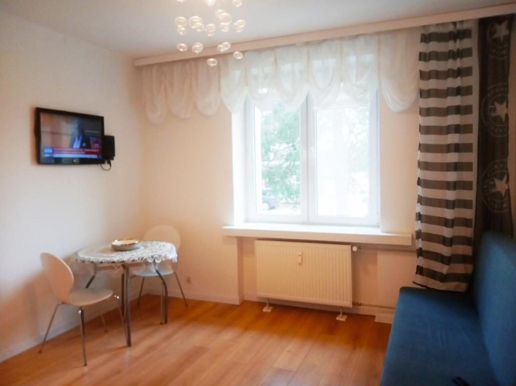 ein Wohnzimmer mit einem Tisch und einem Fenster in der Unterkunft Mieszkanie ul Przędzalniana in Białystok