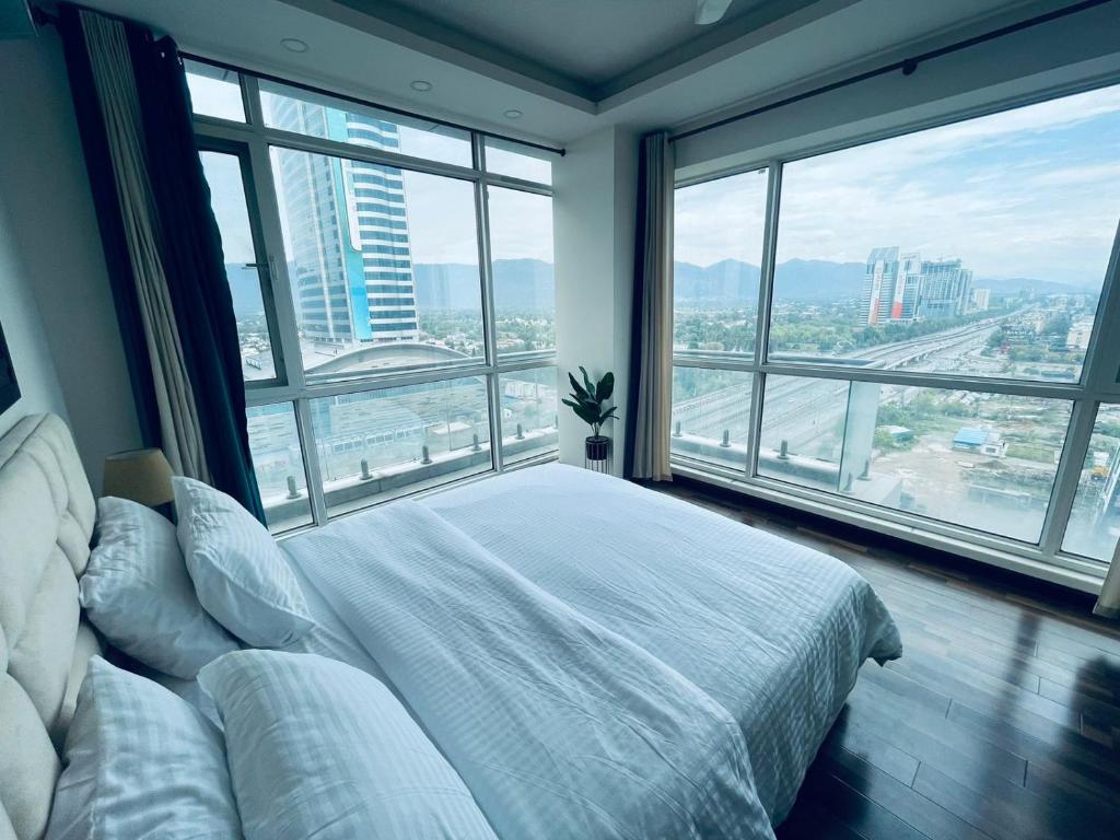 1 dormitorio con cama blanca y ventanas grandes en High Rise Presidential Suite in Elysium Opp Centaurus, en Islamabad