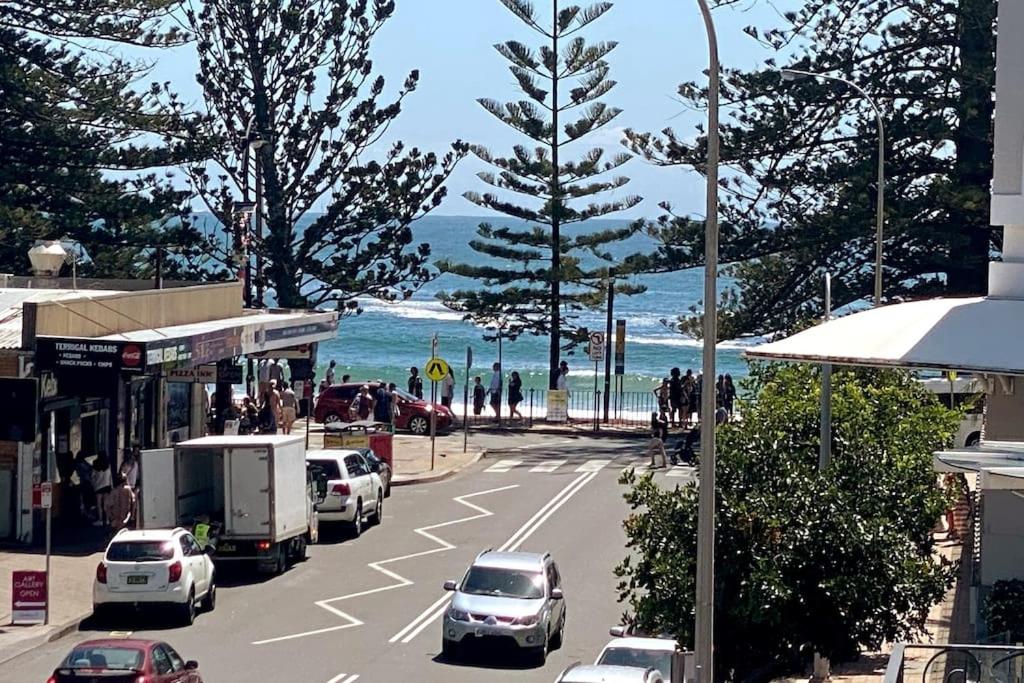 a street with cars parked on the side of the beach at The Retreat Terrigal 3bed 100m to beach in Terrigal