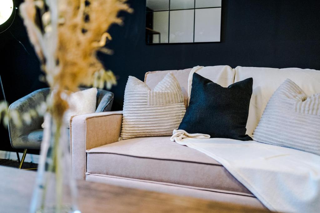 a couch with pillows on it in a living room at Rest&Recharge at a Spacious Townhouse by the Etihad (5mins to City Centre, Free Secure Parking) in Manchester