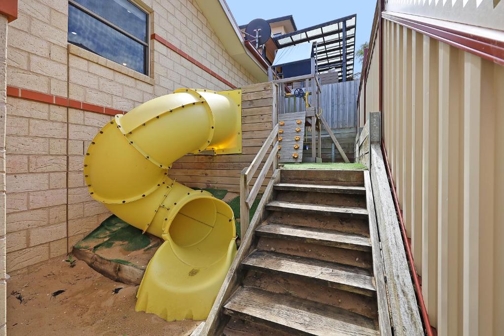 a yellow slide on the side of a building at Hillside - Family Orientated Holiday Home in Warrnambool