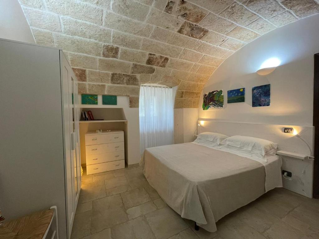 una camera con letto e parete in pietra di Il Vecchio Carrubo - Villa con piscina a sfioro a Macchia di Monte