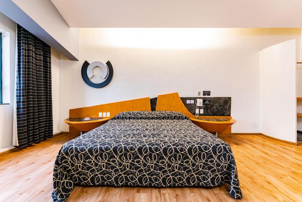 een slaapkamer met een bed en 2 stoelen bij Hotel Pasadena CDMX in Mexico-Stad