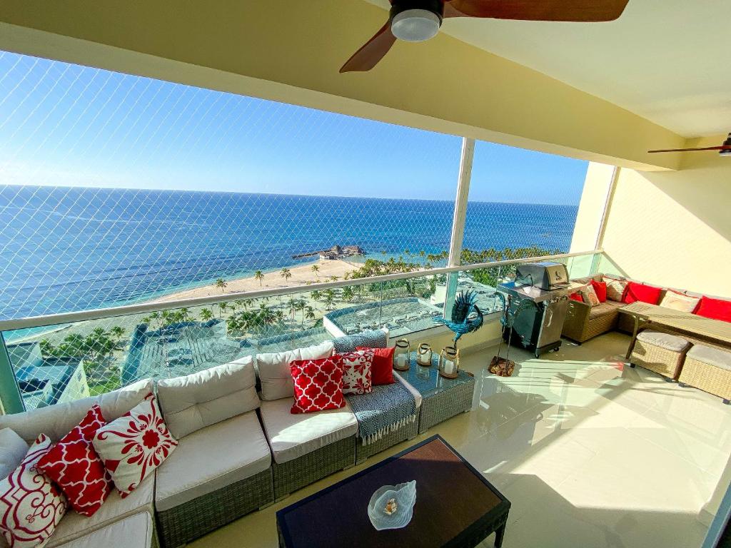 a living room with a couch and a view of the ocean at JUAN DOLIO villa Palmera in Los Corrales