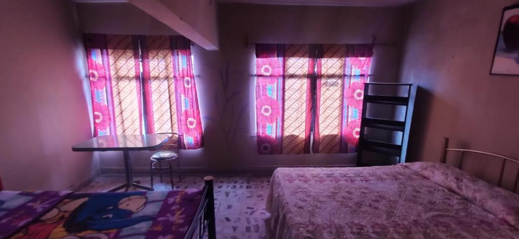 1 Schlafzimmer mit 2 Fenstern, einem Bett und einem Tisch in der Unterkunft La Providencia in Orizaba