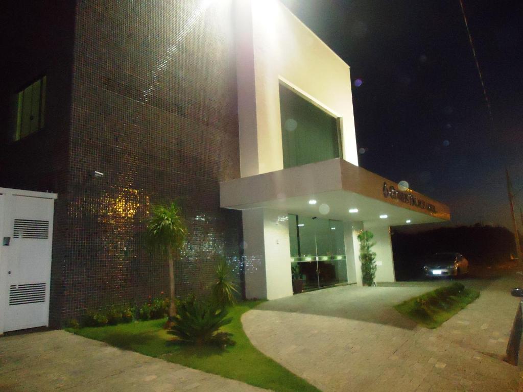 a large building with a sign on it at night at Guines Palace Hotel in Patrocínio