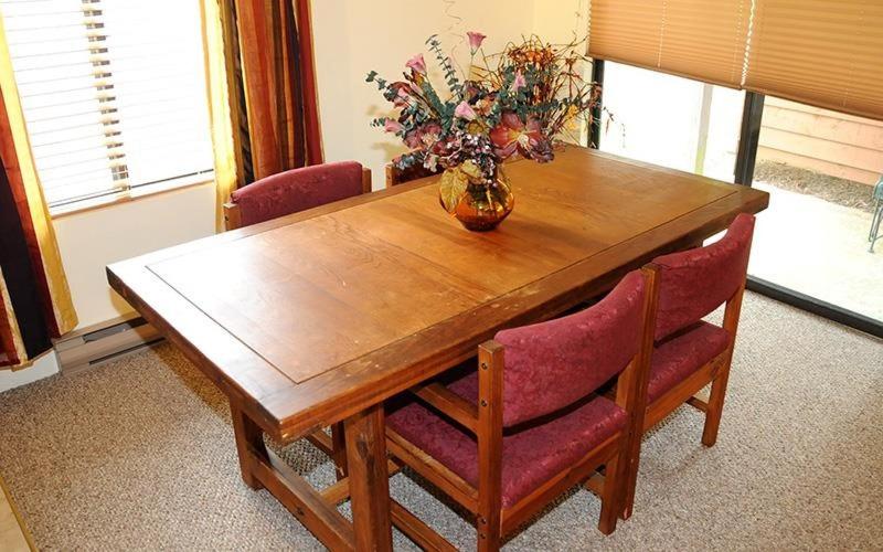 a wooden table with chairs and a vase of flowers on it at Seven Springs Swiss Mountain 1 Bedroom Standard Condo condo in Champion