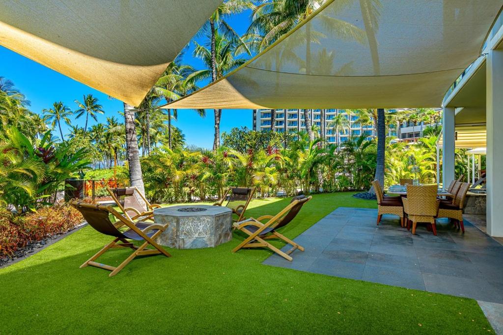 a patio with chairs and a table on grass at Andaz Villa 810 villa in Wailea