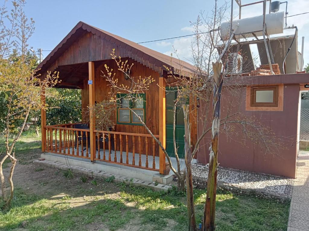 a house with a porch with a fence at Bungalow with access to a large garden near beach in Kemer