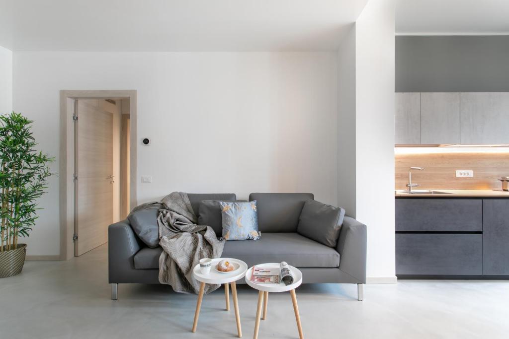 a living room with a couch and two tables at C-Apartment Civico88 in Padova