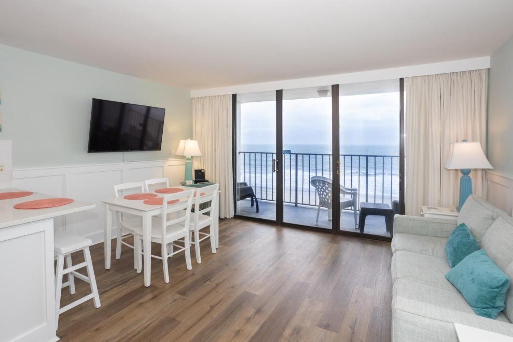 a living room with a couch and a table at 0606 Endless Summer by Atlantic Towers in Carolina Beach