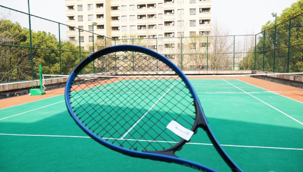 a tennis racket sitting on a tennis court at Belgravia Serviced Residence Wuxi in Wuxi