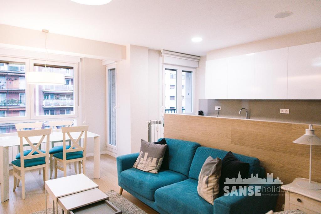un soggiorno con divano blu e una cucina di Anoeta by SanSe Holidays a San Sebastián