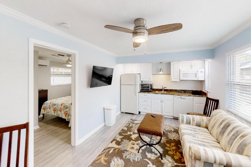 a living room with a couch and a kitchen and a bed at Dolphin Court #3 in St. Pete Beach