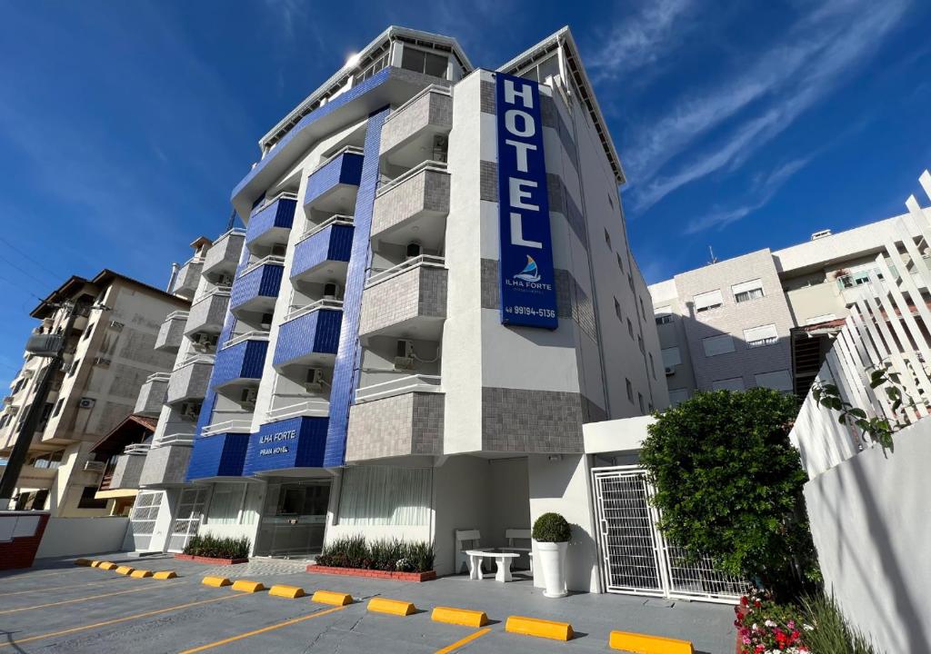 a building with a blue sign on the side of it at Ilha Forte Praia Hotel in Florianópolis