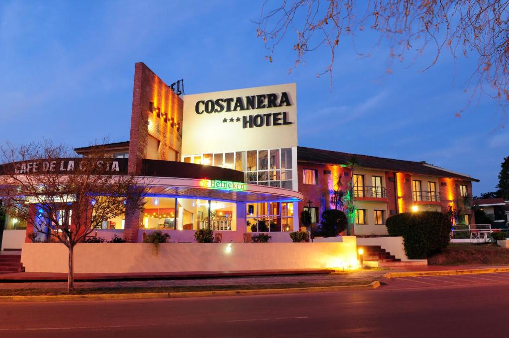 a building with a sign for a hotel at night at Costanera Hotel in Villa Carlos Paz