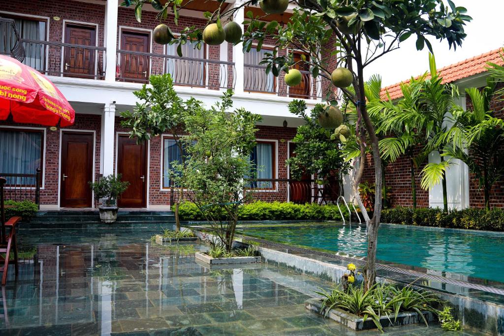 un hotel con piscina frente a un edificio en Tam Coc international friends, en Ninh Binh