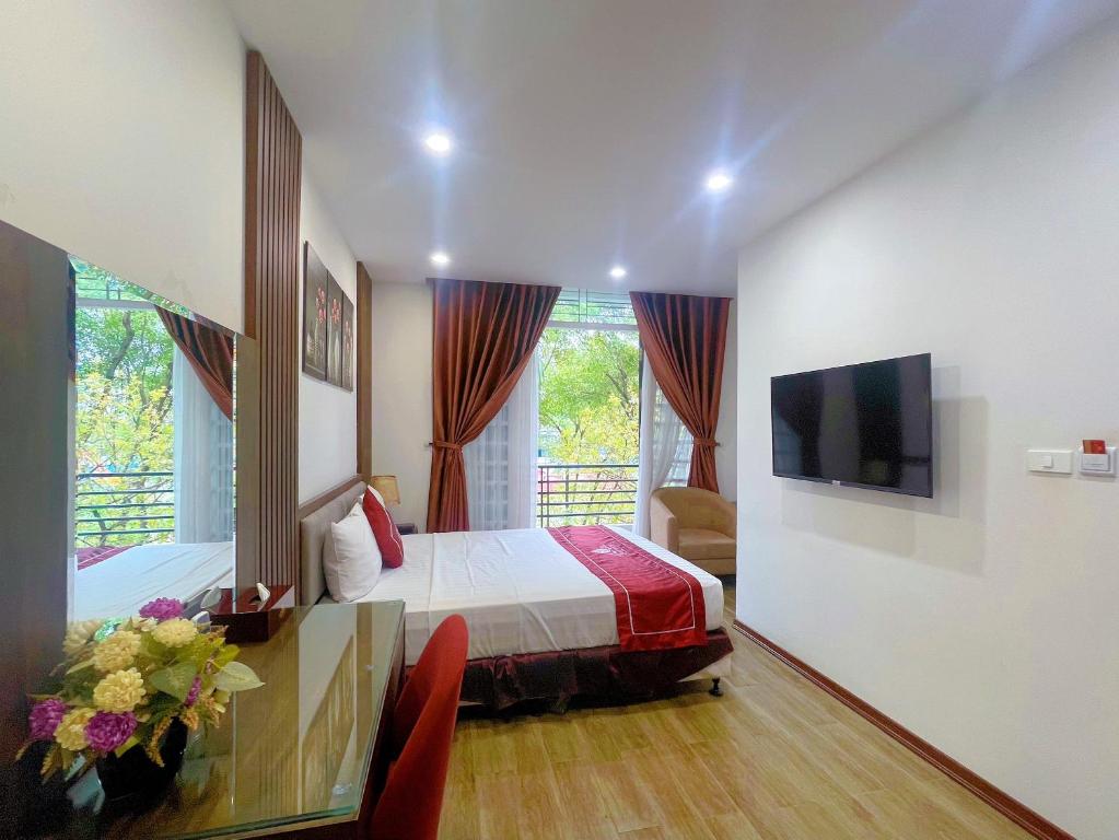 a hotel room with a bed and a television at Rosy Motel Trung Yên in Hanoi