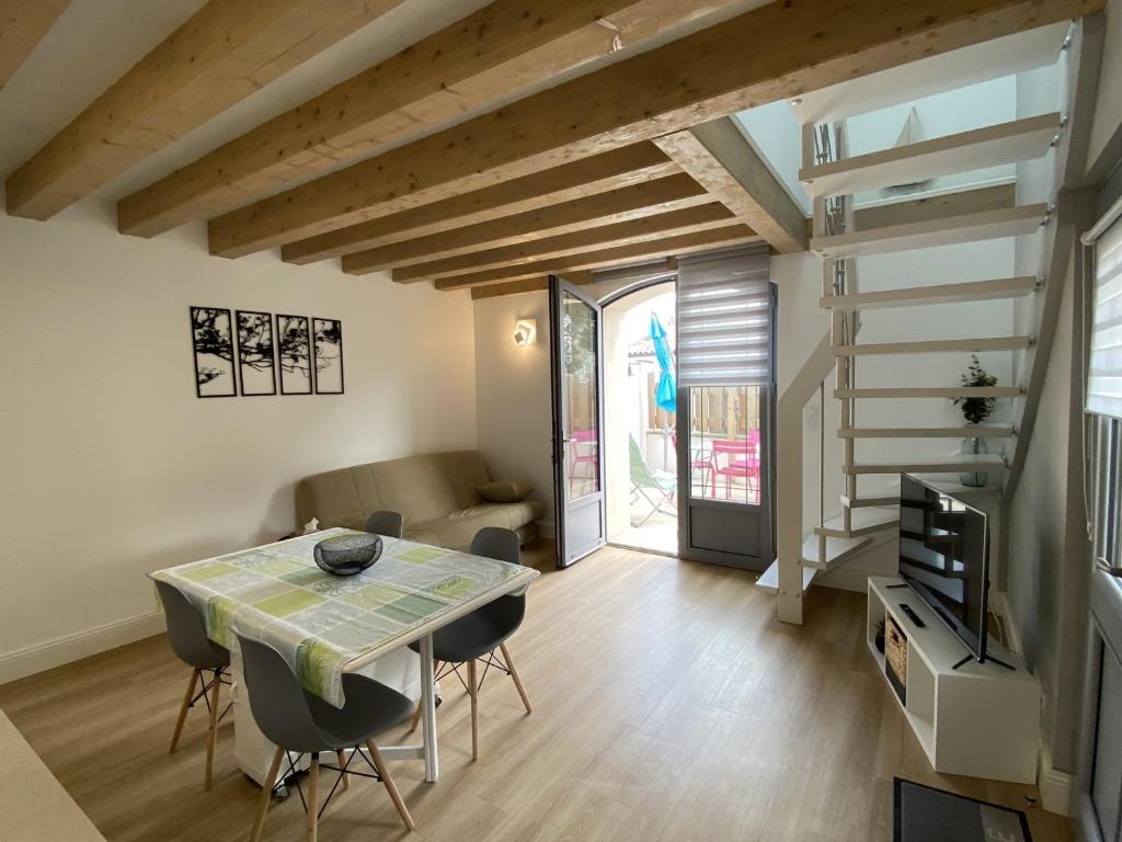 una pequeña sala de estar con mesa y sillas. en Maison Fouras, 3 pièces, 5 personnes - FR-1-709-34, en Fouras
