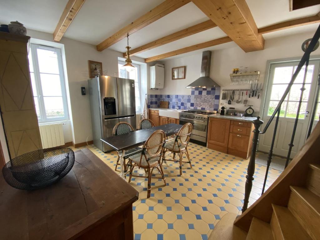 a kitchen with a table and chairs and a refrigerator at Maison Fouras, 6 pièces, 8 personnes - FR-1-709-39 in Fouras