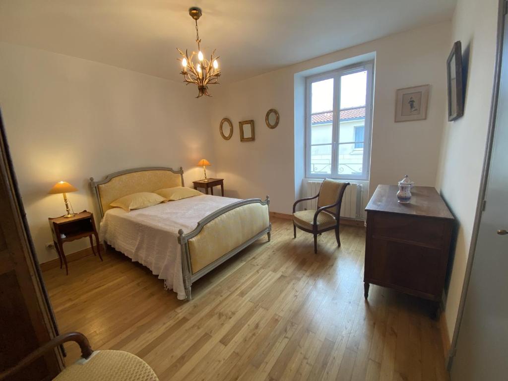a bedroom with a bed and a table and a chair at Maison Fouras, 6 pièces, 8 personnes - FR-1-709-39 in Fouras
