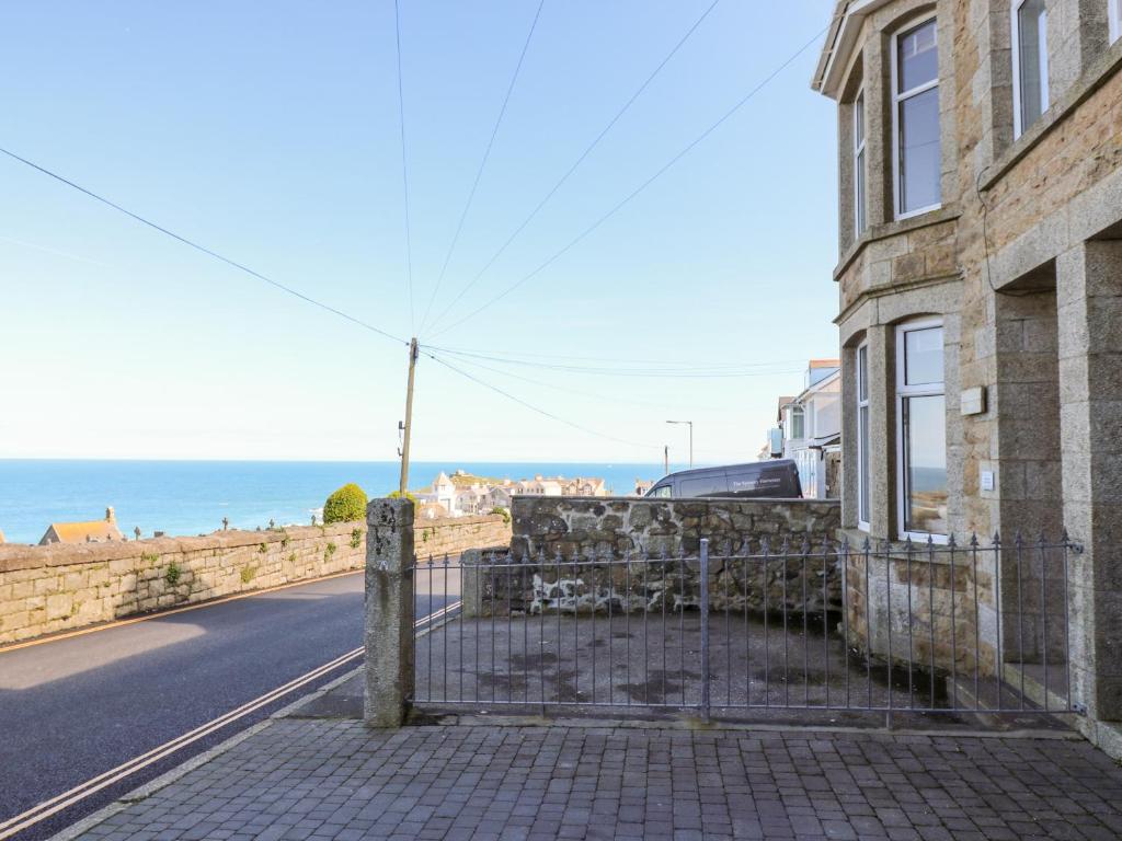una casa al lado de una carretera al lado del océano en Porthmeor Beach House, en St Ives