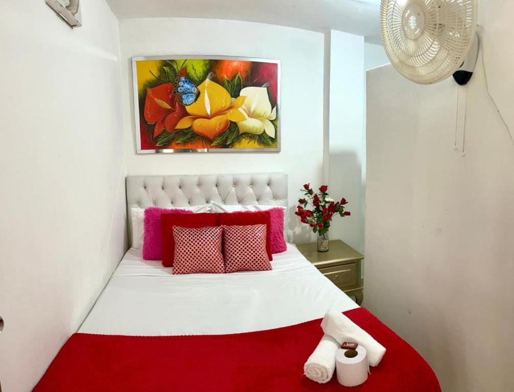 een slaapkamer met een rood en wit bed en een schilderij bij Costa atlantico in Barranquilla