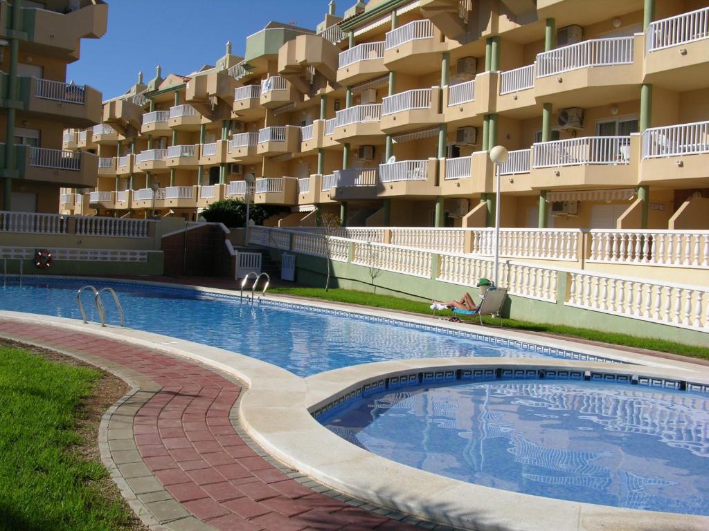 ラ・マンガ・デル・マール・メノールにあるVillas de Frente - 1407の大きなアパートメントの建物の前にスイミングプールがあります。