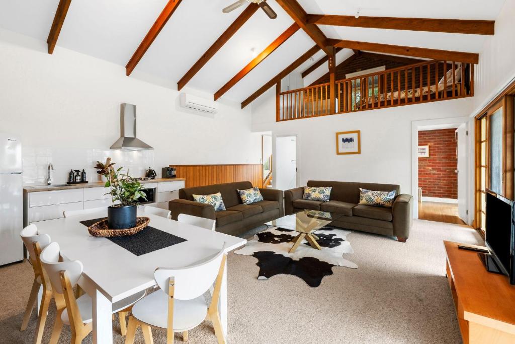 ein Wohnzimmer mit einem Tisch und einem Sofa in der Unterkunft A home amongst the gum trees in Torquay