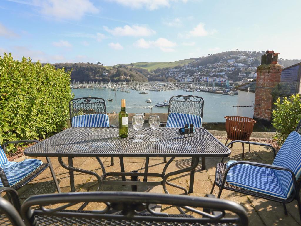 a table with a bottle of wine and wine glasses at Juniper Cottage in Dartmouth