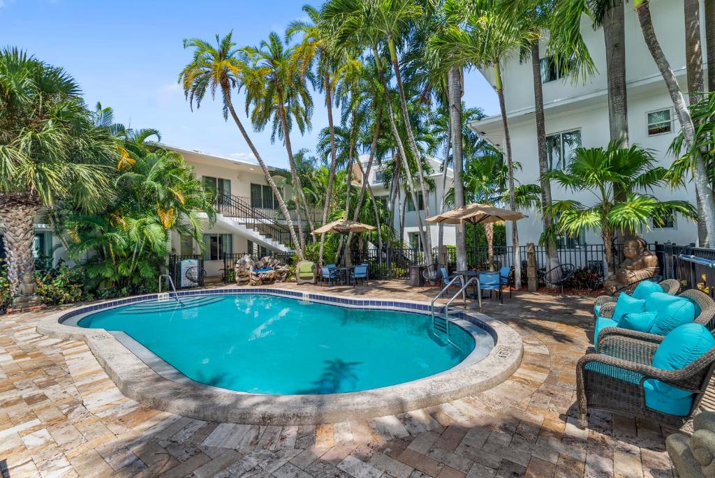 una piscina en un complejo con sillas y palmeras en Isle of Venice Residence and Marina, en Fort Lauderdale