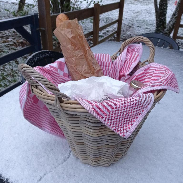 a basket filled with pink and white items on a table at CAMPING LE BEL AIR Mobil home L&#39;OLIVIER 4 personnes in Limogne-en-Quercy