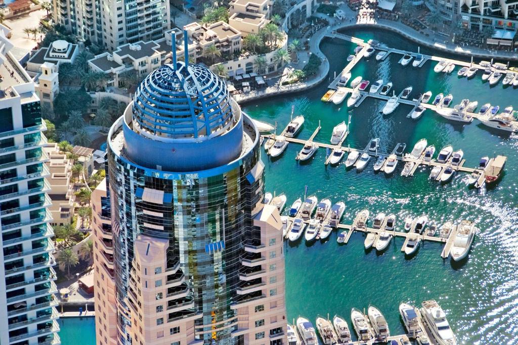 an aerial view of a building with a marina with boats at Dubai Marriott Harbour Hotel And Suites in Dubai