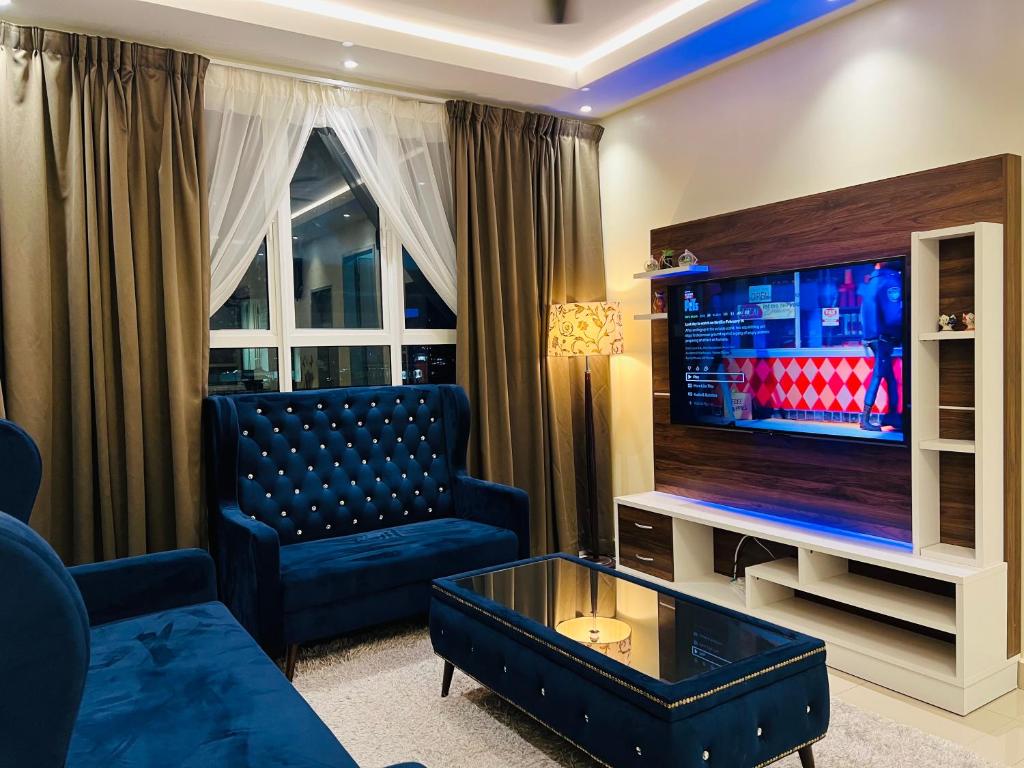 Una sala de estar con un sofá y un televisor. en Aishiteru Homestay Ladang Tanjung, Kuala Terengganu with POOL, en Kuala Terengganu