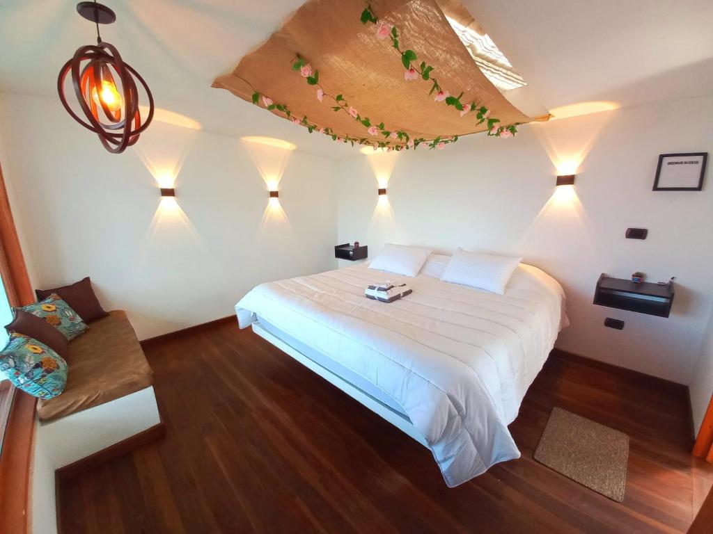 a bedroom with a white bed with lights on it at Bajo las estrellas deluxe in Ráquira
