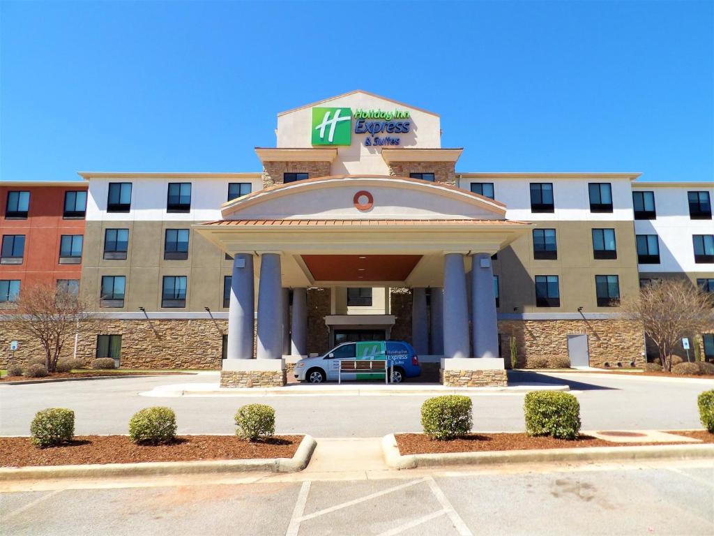 un hotel con aparcamiento frente a un edificio en Holiday Inn Express & Suites - Huntsville Airport, an IHG Hotel, en Madison