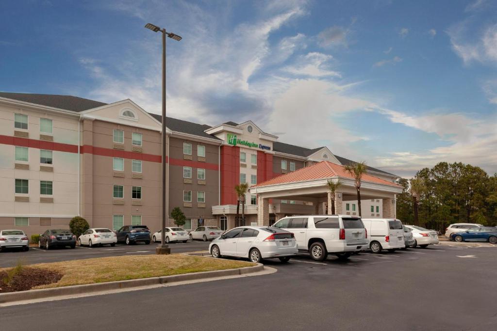 um parque de estacionamento em frente a um hotel com carros estacionados em Holiday Inn Express Myrtle Beach-Broadway at the Beach, an IHG Hotel em Myrtle Beach