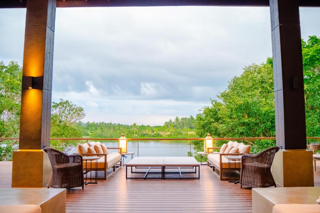 a deck with couches and a table and chairs at Lily Pod in Panadura