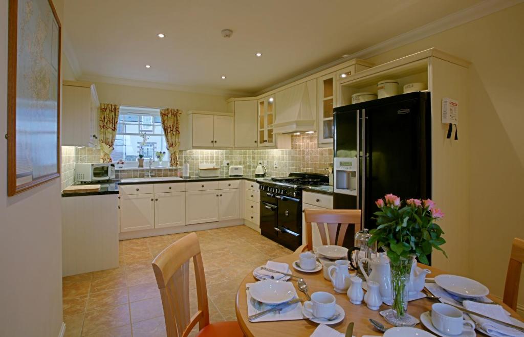 a kitchen with a table with plates and flowers on it at Loaninghead Holidays in Drymen