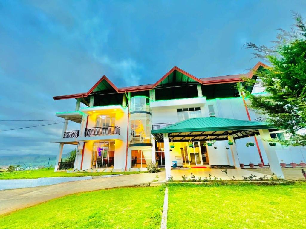 uma casa com um relvado verde em frente em White City Villa em Nuwara Eliya