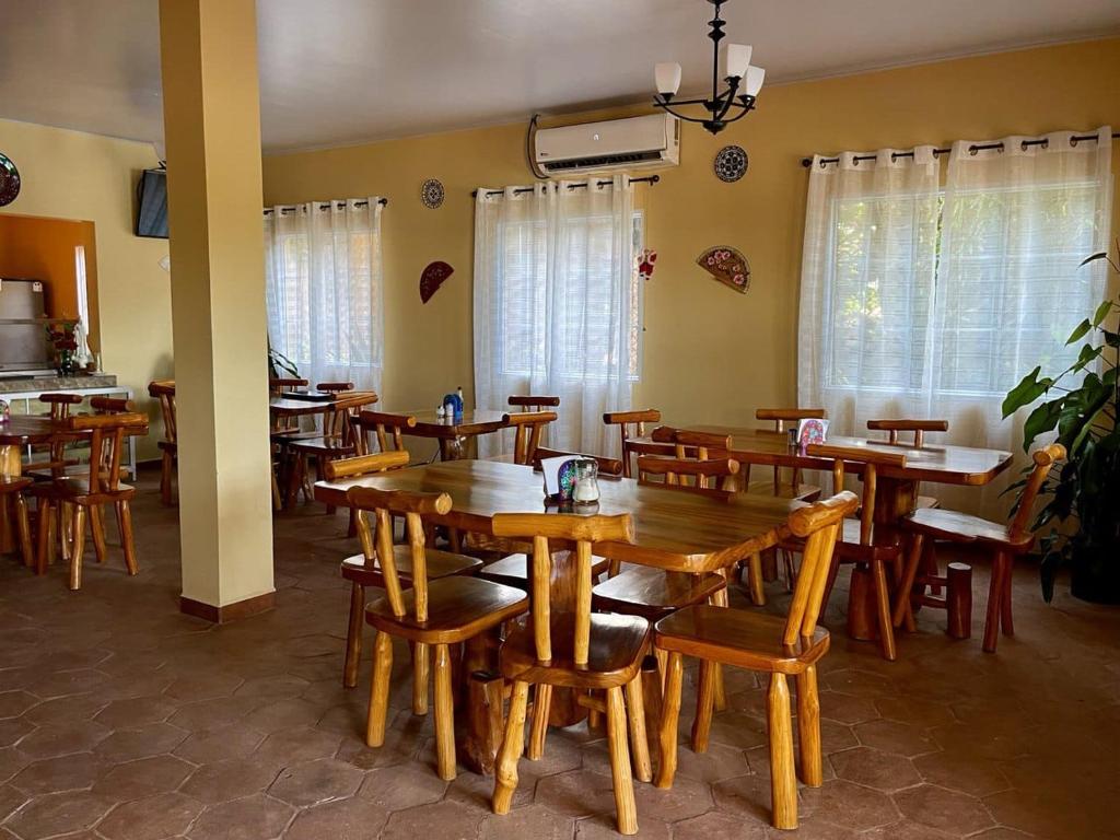 a dining room with wooden tables and chairs at Hotel y Restaurante Virgen de Fátima in La Ceiba
