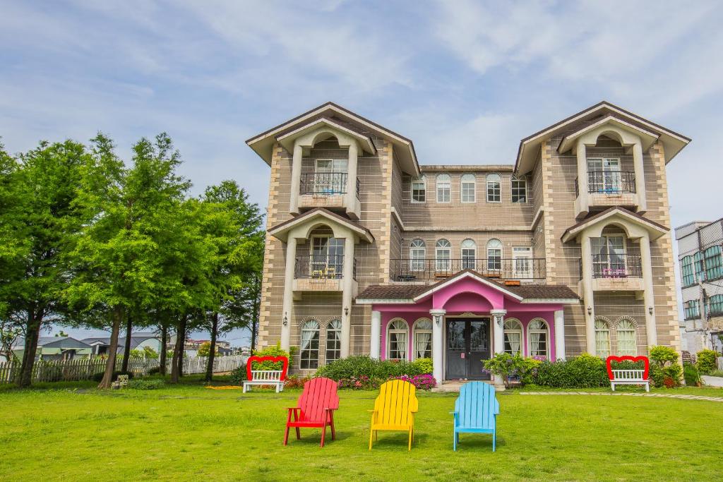 a house with colorful chairs in front of it at 伊莎愛莉溜滑梯親子民宿 in Wujie