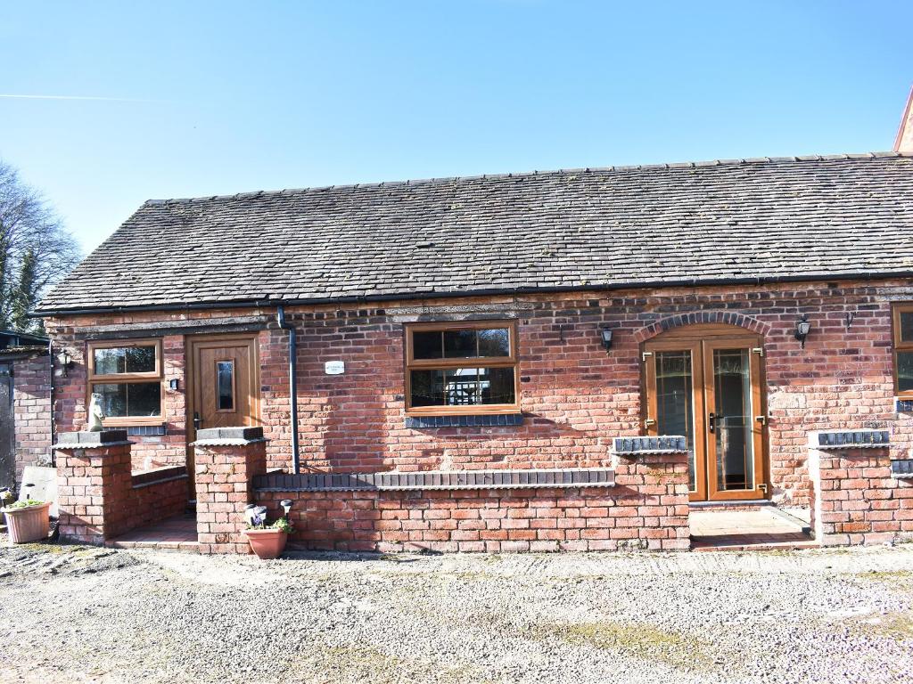 an old brick house with a porch and windows at Brookside Cottage - Uk42869 in Burntwood