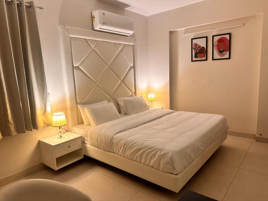 - une chambre avec un grand lit blanc et une chaise dans l'établissement Celesto Luxury Residences by Chakola’s Hospitality, à Thrissur