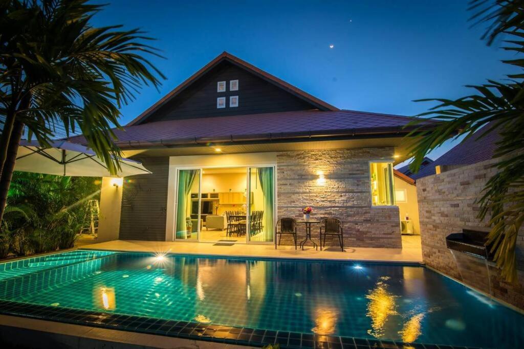 a swimming pool in front of a house at the time poolvilla3 in Jomtien Beach